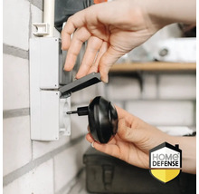 Een persoon steekt een insectenverdelger in een stopcontact met klapdeksel.