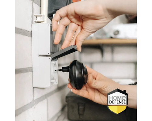 Een persoon steekt een insectenverdelger in een stopcontact met klapdeksel.