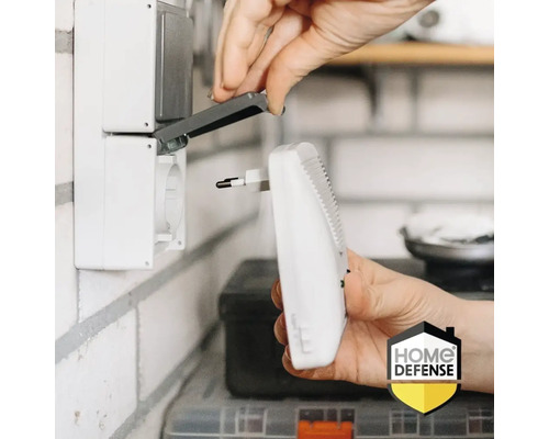 Iemand steekt een elektrische insectenverdelger in een stopcontact. Home Defense logo.