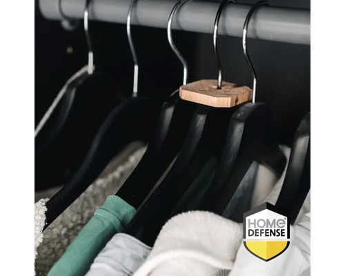 Zwarte kledinghangers met cederhouten stuk aan de haak en hangende kleding aan een kledingroede