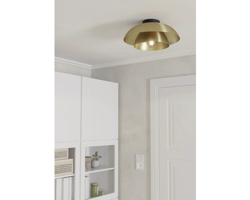 Goudkleurige plafondlamp in een lichte ruimte.