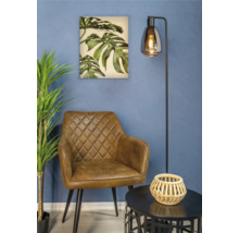 Woonkamer met bruine fauteuil, vloerlamp, tafel en schilderij