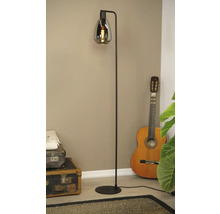 Vloerlamp met rookglazen kap naast gitaar en vintage koffers