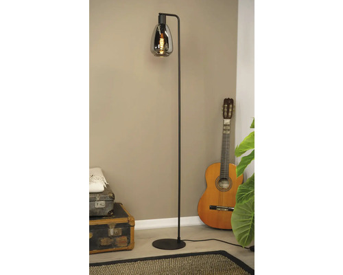 Vloerlamp met rookglazen kap naast gitaar en vintage koffers