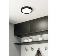 Plafondlamp in moderne hal met kapstok en decoratie.