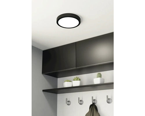 Plafondlamp in moderne hal met kapstok en decoratie.