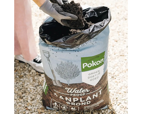 Persoon schept potgrond uit een zak van Pokon.