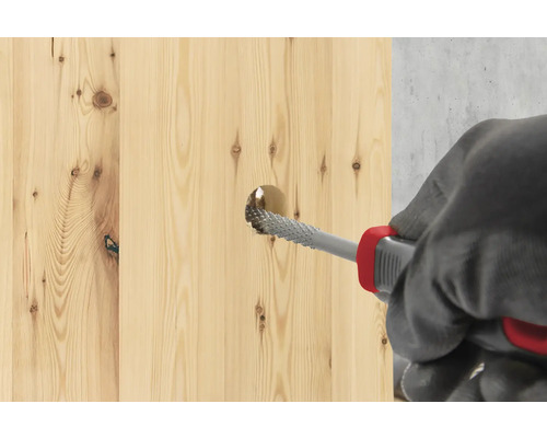 Een houten plank wordt bewerkt met een rasp.