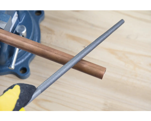 Koperen buis in bankschroef met metalen vijl