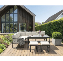 Tuinmeubelset met tafel en krukken op een houten terras voor een huis