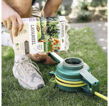 Persoon giet Pokon lavameel in een tuingereedschap op een gazon.
