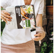 Een persoon giet Pokon biologische druivenmest uit een kartonnen verpakking in een witte maatbeker voor nauwkeurige dosering.