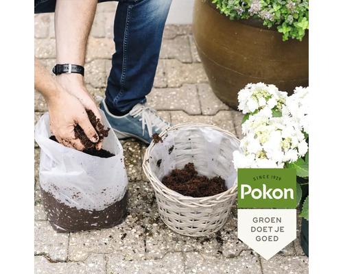 Een persoon vult een gevlochten mand met potgrond uit een zak met de handen. Pokon Logo.