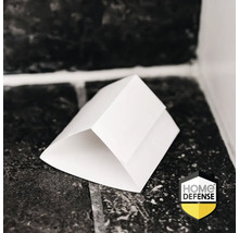 Witte driehoekige insectenval op een tegelvloer geplaatst. Home Defense Logo.
