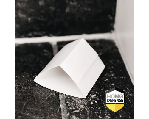 Witte driehoekige insectenval op een tegelvloer geplaatst. Home Defense Logo.
