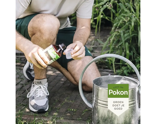 Persoon giet vloeibare plantenvoeding uit een fles in een maatbeker naast een zinken gieter in een tuin, Pokon Logo.