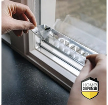 Handen monteren een metalen strip op een kozijn voor beveiliging. Home Defense Logo.