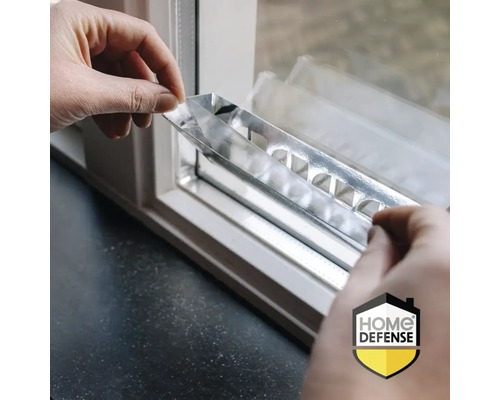 Handen monteren een metalen strip op een kozijn voor beveiliging. Home Defense Logo.