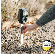Ultrasone dierenverjager op zonne-energie met bewegingsmelder wordt in de grond geplaatst. Home Defense Logo.