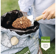 Een persoon schept met een tuinschepje houtsnippers uit een zak. Pokon Logo.