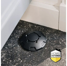 Zwarte lokdoos op een donkere vloer naast een witte plint, Home Defense Logo.