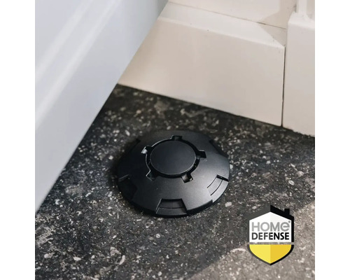 Zwarte lokdoos op een donkere vloer naast een witte plint, Home Defense Logo.