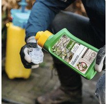 Een persoon met werkhandschoenen giet Pokon onkruidverdelger concentraat uit een groene fles in een maatbeker, met een gele drukspuit op de achtergrond.