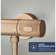 Detailopname van een bronzen kraan met geribbelde handgreep en waterbesparende knop.