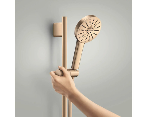 Grohe handdoucheset met ronde douchekop en in hoogte verstelbare glijstang. Een hand stelt de douchehouder op de stang in.