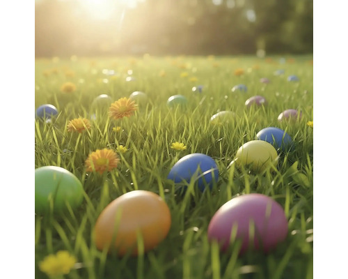 Gekleurde paaseieren in groen gras op een weide met gele bloemen in helder zonlicht.