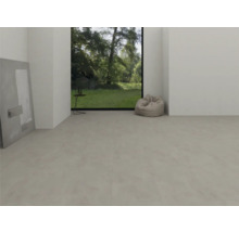 Moderne, lichte kamer met lichtgrijze vinylvloer met betonlook, groot raam met uitzicht op de tuin en een zitzak.