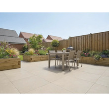 Licht en ruim terras met grootformaat vloertegels, modern tuinmeubilair, houten borders en een houten schutting.