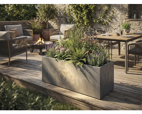 Grote rechthoekige plantenbak met betonlook op een houten terras in een modern ingerichte tuin met zithoek en vuurschaal.
