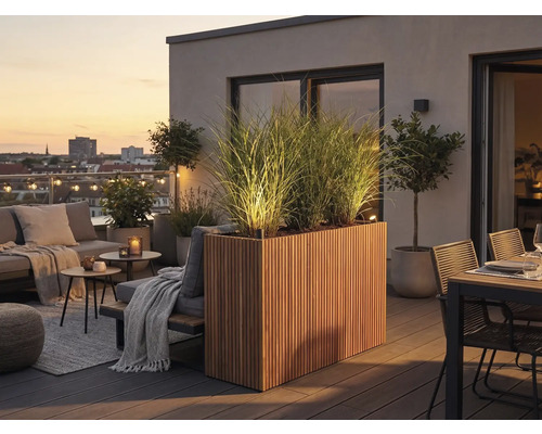 Modern dakterras met verlichte houten plantenbak, hoge grassen, loungemeubels en eethoek bij zonsondergang.