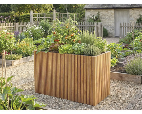 Hoge plantenbak van verticale houten latten met tomaten en kruiden in een lichte, georganiseerde tuin met grindpaden.