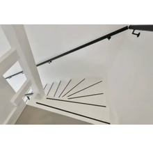 Witte houten spiltrap met zwarte antislipstrips op de treden en zwarte trapleuning.