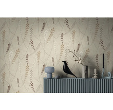 Vliesbehang met botanisch patroon van takken en bladeren in natuurtinten achter een blauw dressoir met decoratieartikelen.