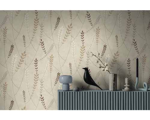 Vliesbehang met botanisch patroon van takken en bladeren in natuurtinten achter een blauw dressoir met decoratieartikelen.