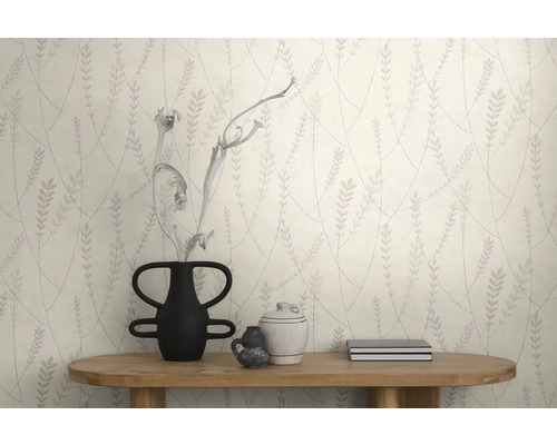 Behang met een bladpatroon achter een houten consoletafel met vaas en decoratieve voorwerpen in een modern interieur.