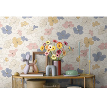 Vliesbehang met een groot bloemenpatroon in pasteltinten op een muur achter een gedecoreerde console.