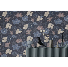 Vliesbehang met abstract bloemenpatroon in blauw, mauve en beige achter een dressoir met decoratieartikelen.