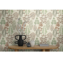 Vliesbehang met botanisch blad- en bloempatroon in gedempte kleuren op een muur achter een houten tafel met decoratieve vazen.