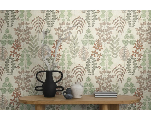 Vliesbehang met botanisch blad- en bloempatroon in gedempte kleuren op een muur achter een houten tafel met decoratieve vazen.