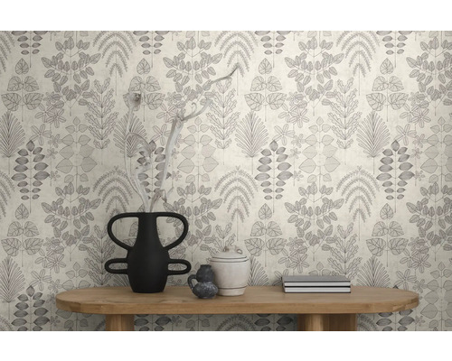 Modern vliesbehang met grafisch bladerpatroon in een lichte kamer achter een houten consoletafel met decoratieve vazen.