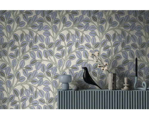 Vliesbehang met bladpatroon en ranken in een modern ingerichte woonkamer met dressoir, decoratiefiguur en vaas.