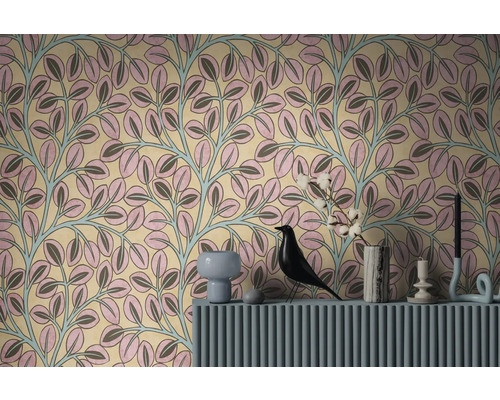 Behang met botanisch patroon van roze en grijze bladeren aan lichtblauw gekleurde ranken achter een blauwe console met decoratie.