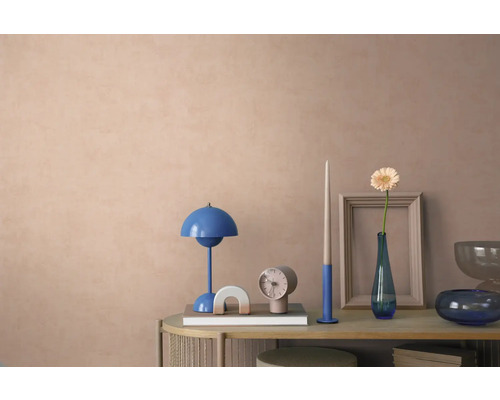 Gedecoreerde console voor een muur met textuur, met een blauwe tafellamp, klok en vaas met bloem in een modern, georganiseerd interieur.