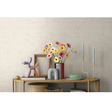 Modern interieur met houten dressoir, boeket gerbera's in een vaas, ballonhond-sculptuur, kandelaars en fotolijst voor een lichte wand.
