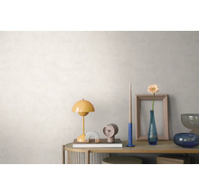 Heldere, georganiseerde opstelling op een houten dressoir voor een lichte wand met textuur, met een gele tafellamp, klok en bloemenvaas.