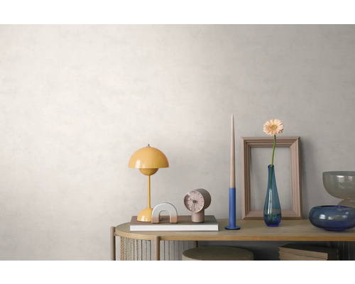 Heldere, georganiseerde opstelling op een houten dressoir voor een lichte wand met textuur, met een gele tafellamp, klok en bloemenvaas.